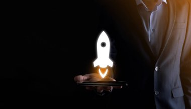 Girişim konsepti, Tablet ve simge roketi tutan İşadamı ekrandan koyu arkaplanda ağ bağlantısı ile fırlıyor ve yükseliyor