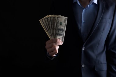 Bir adam dolarları elinde tutar. Bir adam dolar sayıyor. Para için. İş adamı para sayar. İş adamı rüşvetçi olur. Dolarlar yakın plan bir fotoğrafın elinde.
