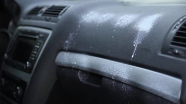 Araba temizliği. Eldivenli bir adam arabanın farlarını temizliyor ve parlamak için siliyor..