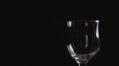 Koyu arkaplanda kırmızı şarap sallıyor. Şarap reklamı için çok güzel görüntüler. Yavaş Hareket .