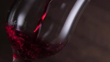 Koyu arkaplanda kırmızı şarap sallıyor. Şarap reklamı için çok güzel görüntüler. Yavaş Hareket .