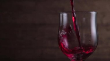 Koyu arkaplanda kırmızı şarap sallıyor. Şarap reklamı için çok güzel görüntüler. Yavaş Hareket .
