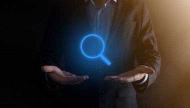 İş adamı ve adam el ele tutuşup cam ikonunu büyütüyorlar. İş dünyası, teknoloji ve internet kavramı