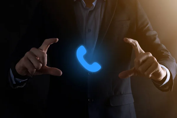 Businessman man in suit on black background hold phone icon.Call Now Business Communication Support Center Customer Service Technology Concept.