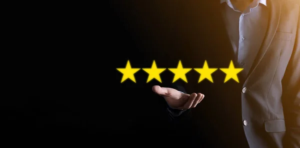Man hand showing on five star excellent rating.pointing five star symbol to increase rating of company.Review, increase rating or ranking, evaluation and classification concept.