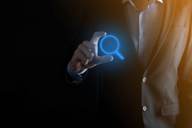 İş adamı ve adam el ele tutuşup cam ikonunu büyütüyorlar. İş dünyası, teknoloji ve internet kavramı