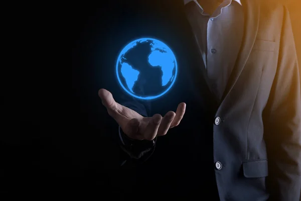 Businessman with protective gesture standing posture hand holding Earth icon , digital globe.