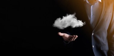 İş adamı el ele tutuşur. Bulut hesaplama konsepti, eli bulutlu genç iş adamına yakınlaşır. Bulut servisi kavramı..