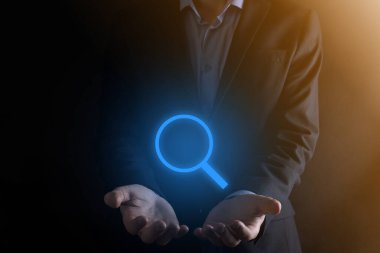 İş adamı ve adam el ele tutuşup cam ikonunu büyütüyorlar. İş dünyası, teknoloji ve internet kavramı