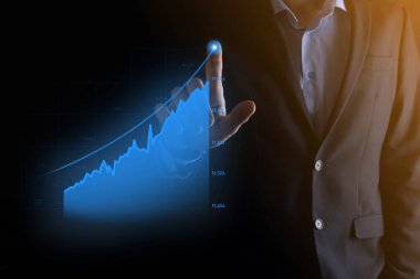 Tablet tutan ve holografik grafikler ve borsa istatistikleri gösteren bir işadamı kâr elde ediyor. Büyüme planlama ve iş stratejisi kavramı. İyi ekonomi formunun dijital ekran görüntüsü