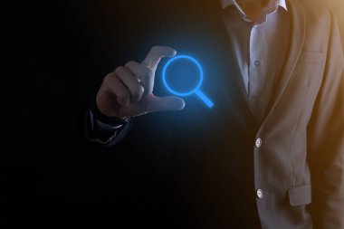 İş adamı ve adam el ele tutuşup cam ikonunu büyütüyorlar. İş dünyası, teknoloji ve internet kavramı