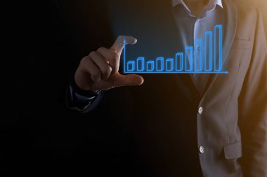 Holografik grafikler ve borsa istatistikleri tutan işadamı kâr elde ediyor. Büyüme planlama ve iş stratejisi kavramı. İyi ekonomi formunun dijital ekran görüntüsü