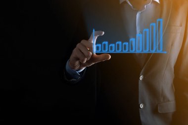 Holografik grafikler ve borsa istatistikleri tutan işadamı kâr elde ediyor. Büyüme planlama ve iş stratejisi kavramı. İyi ekonomi formunun dijital ekran görüntüsü