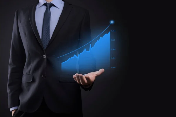 Businessman on a black background presses, presses a finger on a positive growth arrow. Graphs of indicators. Business development and finance concept.