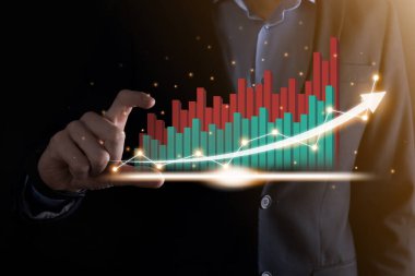 Holografik grafikler ve borsa istatistikleri tutan işadamı kâr elde ediyor. Büyüme planlama ve iş stratejisi kavramı. İyi ekonomi formunun dijital ekran görüntüsü