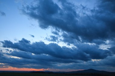 Fırtınalı gökyüzü, gün batımında fırtına, güzel bir güneşle.