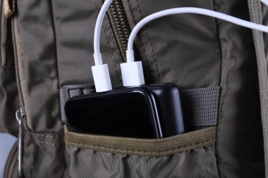 Telefon şarjı, elektrik faturası akıllı telefon, enerji bankasıyla cep telefonu. Sırt çantasındaki Güç Bankası 'nın derinliği