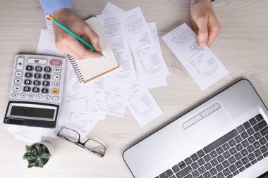 Masa başında hesap makinesi kullanan tanınmayan bir işadamı. Ofisteki maliyeti hesaplayarak not alın. Finans muhasebe kavramı. vergi, alışveriş, maliyet yönetimi.