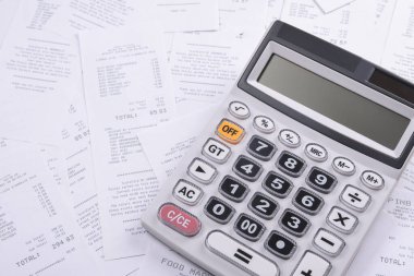 Ahşap bir arka planda, mağazadan gelen bir yığın çeke güvendiğin için hesap makinesi. Üst Manzara. Metin için yer. Boşluğu kopyala.