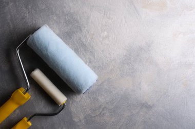 Gri beton zemini boyamak için silindirler. Üst manzara.