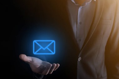 İş adamı elinde e-posta simgesi ile bizimle iletişim kurar ve kişisel bilgilerinizi spam postalarından korur. Müşteri hizmetleri çağrı merkezi bizimle iletişim kurar.