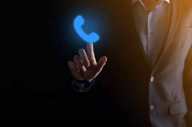 Siyah arka planda takım elbiseli bir iş adamı telefon ikonu. İş İletişim Destek Merkezi Müşteri Hizmetleri Teknolojisi Konseptini ara..