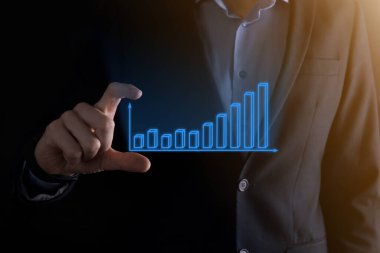 Holografik grafikler ve borsa istatistikleri tutan işadamı kâr elde ediyor. Büyüme planlama ve iş stratejisi kavramı. İyi ekonomi formunun dijital ekran görüntüsü