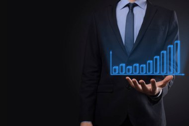 Holografik grafikler ve borsa istatistikleri tutan işadamı kâr elde ediyor. Büyüme planlama ve iş stratejisi kavramı. İyi ekonomi formunun dijital ekran görüntüsü