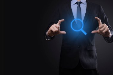 İş adamı ve adam el ele tutuşup cam ikonunu büyütüyorlar. İş dünyası, teknoloji ve internet kavramı