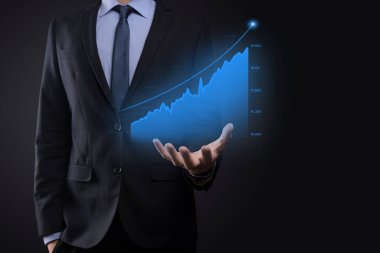 Holografik grafikler ve borsa istatistikleri tutan işadamı kâr elde ediyor. Büyüme planlama ve iş stratejisi kavramı. İyi ekonomi formunun dijital ekran görüntüsü
