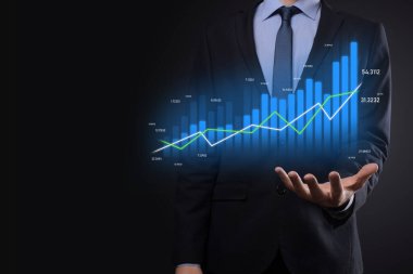 Holografik grafikler ve borsa istatistikleri tutan işadamı kâr elde ediyor. Büyüme planlama ve iş stratejisi kavramı. İyi ekonomi formunun dijital ekran görüntüsü