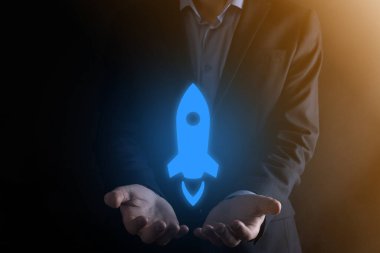 Girişim konsepti, Tablet ve simge roketi tutan İşadamı ekrandan koyu arkaplanda ağ bağlantısı ile fırlıyor ve yükseliyor