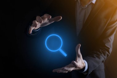 İş adamı ve adam el ele tutuşup cam ikonunu büyütüyorlar. İş dünyası, teknoloji ve internet kavramı