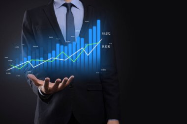 Holografik grafikler ve borsa istatistikleri tutan işadamı kâr elde ediyor. Büyüme planlama ve iş stratejisi kavramı. İyi ekonomi formunun dijital ekran görüntüsü