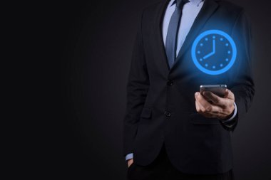 İş adamı, saatin simgesini okla tutar. İşlerin hızlı yürütülmesi. İş zamanı yönetimi ve iş zamanı para kavramlarıdır..