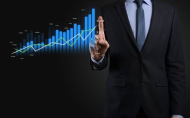 Holografik grafikler ve borsa istatistikleri tutan işadamı kâr elde ediyor. Büyüme planlama ve iş stratejisi kavramı. İyi ekonomi formunun dijital ekran görüntüsü