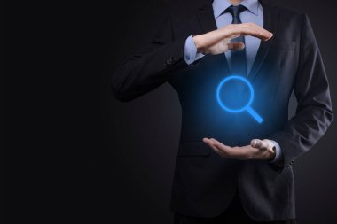 İş adamı ve adam el ele tutuşup cam ikonunu büyütüyorlar. İş dünyası, teknoloji ve internet kavramı