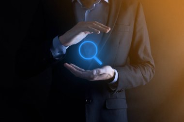 İş adamı ve adam el ele tutuşup cam ikonunu büyütüyorlar. İş dünyası, teknoloji ve internet kavramı