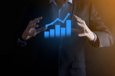 İş adamı elinde pozitif kar artışı olan bir grafik tutuyor. Grafik büyümesi ve grafik artışı işlerinde olumlu göstergeler. Daha kârlı ve büyüyen