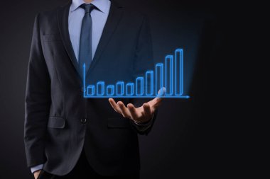 Holografik grafikler ve borsa istatistikleri tutan işadamı kâr elde ediyor. Büyüme planlama ve iş stratejisi kavramı. İyi ekonomi formunun dijital ekran görüntüsü