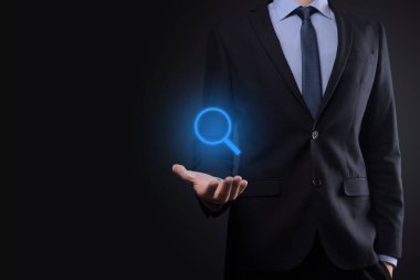 İş adamı ve adam el ele tutuşup cam ikonunu büyütüyorlar. İş dünyası, teknoloji ve internet kavramı