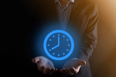 İş adamı, saatin simgesini okla tutar. İşlerin hızlı yürütülmesi. İş zamanı yönetimi ve iş zamanı para kavramlarıdır..