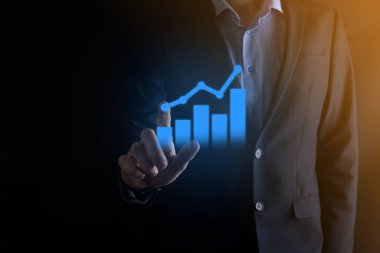 İş adamı elinde pozitif kar artışı olan bir grafik tutuyor. Grafik büyümesi ve grafik artışı işlerinde olumlu göstergeler. Daha kârlı ve büyüyen