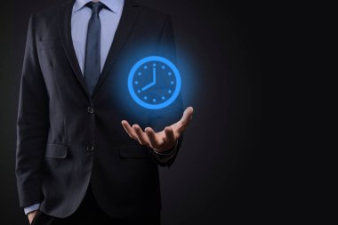 İş adamı, saatin simgesini okla tutar. İşlerin hızlı yürütülmesi. İş zamanı yönetimi ve iş zamanı para kavramlarıdır..