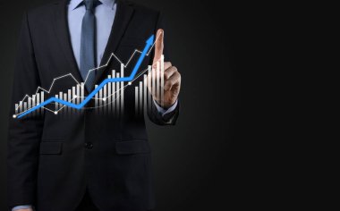 Holografik grafikler ve borsa istatistikleri tutan işadamı kâr elde ediyor. Büyüme planlama ve iş stratejisi kavramı. İyi ekonomi formunun dijital ekran görüntüsü