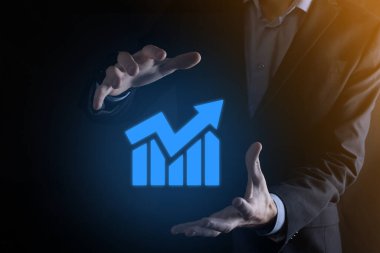 İş adamı elinde pozitif kar artışı olan bir grafik tutuyor. Grafik büyümesi ve grafik artışı işlerinde olumlu göstergeler. Daha kârlı ve büyüyen