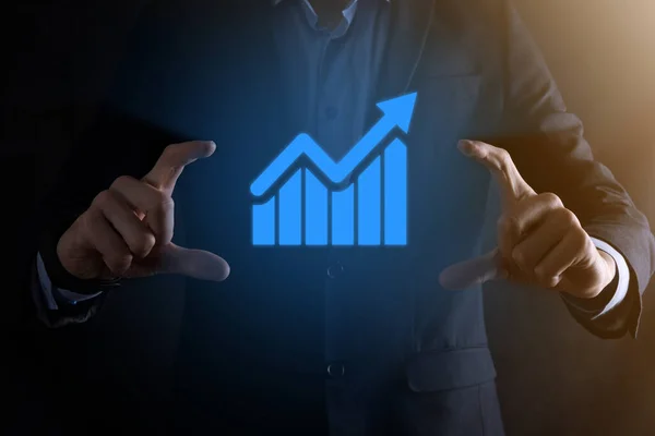 Businessman man holding a graph with positive profits growth. plan graph growth and increase of chart positive indicators in his business.more profitable and growing