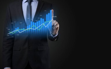 Holografik grafikler ve borsa istatistikleri tutan işadamı kâr elde ediyor. Büyüme planlama ve iş stratejisi kavramı. İyi ekonomi formunun dijital ekran görüntüsü