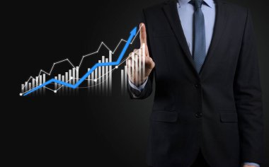 Holografik grafikler ve borsa istatistikleri tutan işadamı kâr elde ediyor. Büyüme planlama ve iş stratejisi kavramı. İyi ekonomi formunun dijital ekran görüntüsü