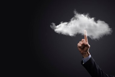 İş adamı el ele tutuşur. Bulut hesaplama konsepti, eli bulutlu genç iş adamına yakınlaşır. Bulut servisi kavramı.